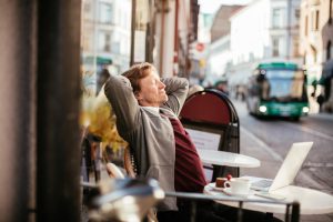 Businessman using laptop at sidewalk cafe
